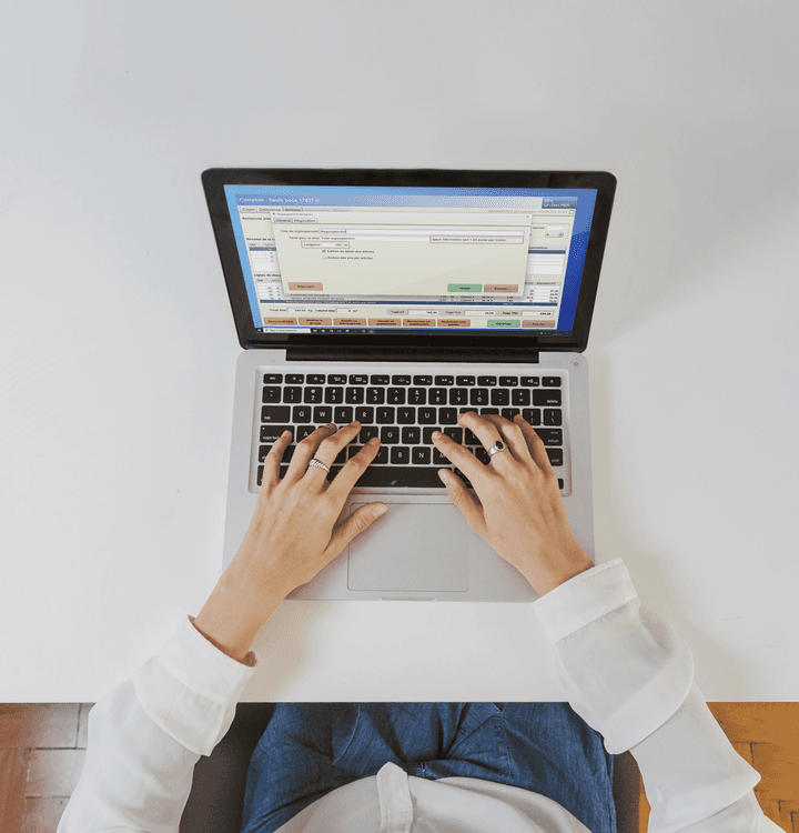 Vue du dessus d'une personne utilisant un ordinateur portable ouvert sur la vente au comptoir dans le logiciel WeNégoce