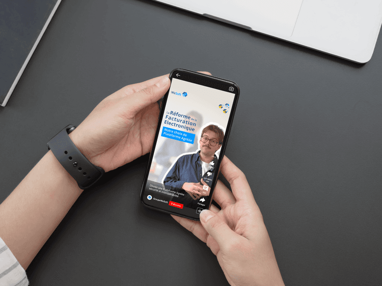 Zoom sur des mains tenant un téléphone avec la vidéo de WeSoft sur le choix de la plateforme agréée concernant la réforme de la facturation électronique